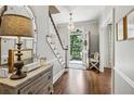 Warm foyer boasts hardwood floors, staircase with a view to the front door, and stylish decor at 735 Longwood Nw Dr, Atlanta, GA 30305