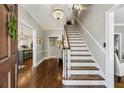 Elegant foyer featuring hardwood floors, staircase, chandelier, and views into the kitchen and living areas at 735 Longwood Nw Dr, Atlanta, GA 30305