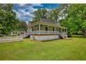 View of charming house and fenced in yard with mature green landscaping at 123 Nelson Street, Newborn, GA 30056