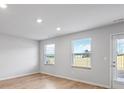 Open living area featuring hardwood floors, many windows, and a glass door for backyard access at 1707 Bouquet Way, Mcdonough, GA 30253
