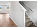 Carpeted stairs with white railing and baseboard next to beautiful hard wood floor at 1707 Bouquet Way, Mcdonough, GA 30253