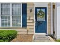 Welcoming front entrance featuring a stylish blue door, adorned with a floral wreath and a 'Welcome' mat at 216 Buckland Dr, Alpharetta, GA 30022
