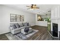 Bright living room featuring hardwood floors, a comfortable gray sofa, and an open layout to the kitchen at 216 Buckland Dr, Alpharetta, GA 30022