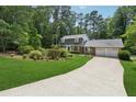 Traditional home featuring a large driveway, attached two-car garage, and a lush green lawn at 626 Cheatham Sw Dr, Marietta, GA 30064