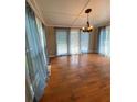 Open dining room with hardwood floors, a modern chandelier, and access to the backyard through sliding doors at 710 Wind Song Trce, Woodstock, GA 30189