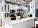 Kitchen includes granite countertops, stainless steel appliances, pendant lighting, and exposed ceiling pipes at 800 Peachtree Ne St # 1319, Atlanta, GA 30308