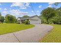 This ranch-style home features an attached garage, a long driveway, and verdant lawn at 256 Teresa Ln, Loganville, GA 30052