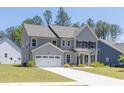 Side view of a gray two story home with an attached two car garage and driveway at 8 Foothills Trl, Sharpsburg, GA 30277