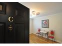 Elegant foyer with dark door, hardwood floors, unique accent furniture, and a bright ceiling light at 1332 Euclid Ave # C, Atlanta, GA 30307