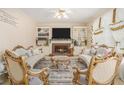 Luxurious living room with built-in bookshelves, fireplace, and ornate, upscale furnishings under a bright ceiling fan at 1644 Beaver Creek Ln, Snellville, GA 30078