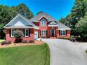 Charming brick home with well-manicured lawn, long driveway, and lush landscaping at 781 Templeton Dr, Loganville, GA 30052