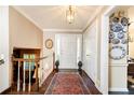 Elegant entryway with hardwood floors, a staircase, and decoratively adorned walls with a vintage-style rug at 3099 Farmington Se Dr, Atlanta, GA 30339
