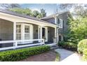 Inviting front porch with white railings and a tiled floor leading to a dark front door, framed by greenery at 3099 Farmington Se Dr, Atlanta, GA 30339