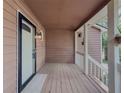 Covered front porch featuring wood floors, painted siding, and a white front door with matching trim at 410 Hunters Cove Ct, Lawrenceville, GA 30044