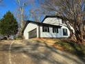 View of house with an attached garage and a long driveway in a wooded area at 4756 Manly Ct, Stone Mountain, GA 30088