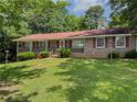 Charming one-story brick home featuring a well-maintained lawn and mature trees at 2000 Stone Mountain Lithonia Rd, Lithonia, GA 30058