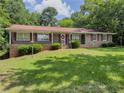 Charming one-story brick home featuring a well-maintained lawn and mature trees at 2000 Stone Mountain Lithonia Rd, Lithonia, GA 30058