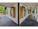 Corner view of a spacious front porch with white railings and decorative wooden shutters at 377 Wyndham Way, Atlanta, GA 30315