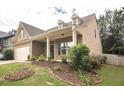 Well-maintained home with inviting front porch, complemented by lush landscaping and manicured lawn at 610 Sunflower Dr, Canton, GA 30114