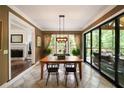 Bright dining room with modern light fixture and sliding glass doors leading to an outdoor porch at 3390 River Ferry Dr, Alpharetta, GA 30022