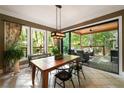 Bright dining room with modern light fixture and sliding glass doors leading to an outdoor porch at 3390 River Ferry Dr, Alpharetta, GA 30022