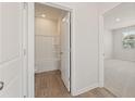 Bathroom with white shower, toilet, and view into secondary bedroom at 7099 Brushwood Bend (Lot 32), Lithonia, GA 30058