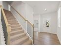 Bright foyer with hardwood flooring, staircase, and front door leading to the exterior at 7099 Brushwood Bend (Lot 32), Lithonia, GA 30058