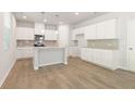 Open-concept kitchen with modern white cabinets, granite countertops, and stainless steel appliances at 7099 Brushwood Bend (Lot 32), Lithonia, GA 30058