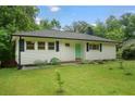 Charming ranch-style home with a well-maintained lawn, white siding, and a vibrant, colorful front door at 2049 Rector Sw Dr, Atlanta, GA 30311
