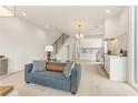 Open-concept living space featuring a modern kitchen, staircase, and stylish furnishings at 370 2Nd St, Fayetteville, GA 30214