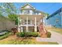 Beautiful two-story home featuring a covered porch and lush front yard landscaping at 628 Warren Ave, Scottdale, GA 30079