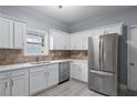 Bright kitchen with white cabinets, stone countertops, and stainless steel appliances at 628 Warren Ave, Scottdale, GA 30079
