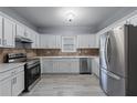 Modern kitchen featuring stainless steel appliances, white cabinets and stone countertops at 628 Warren Ave, Scottdale, GA 30079