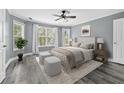 Comfortable main bedroom with soft gray walls, a ceiling fan, and large windows at 628 Warren Ave, Scottdale, GA 30079
