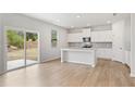 Bright kitchen featuring white cabinets, a granite island, stainless steel appliances, and sliding glass doors at 7193 Brushwood Bend (Lot 33), Lithonia, GA 30058