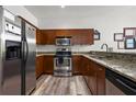 Well-equipped kitchen with stainless steel appliances, granite countertops, and wood finish cabinets and light woodgrain flooring at 870 Mayson Turner Rd Nw # 1111, Atlanta, GA 30314