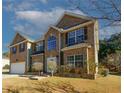 Charming two-story brick home with a well-manicured lawn and a two car garage on a sunny day at 3554 Umatilla Sw Ln, South Fulton, GA 30331