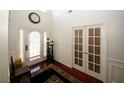 Bright foyer with hardwood floors, high ceilings, and decorative lighting fixtures near the white front door at 3554 Umatilla Sw Ln, South Fulton, GA 30331