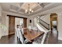 Elegant dining room featuring coffered ceiling and seating for six next to staircase at 4191 Secret Shoals Way, Buford, GA 30518