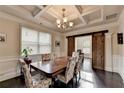Elegant dining room features coffered ceiling, sliding barn door, and seating for six at 4191 Secret Shoals Way, Buford, GA 30518