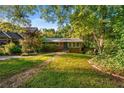 Traditional one-story home featuring a lush green lawn, mature trees, and a well-maintained exterior at 511 Oakview Rd, Decatur, GA 30030