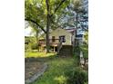 A wooden deck and stairs overlook the yard of this charming yellow cottage home at 1238 Trenton St, Atlanta, GA 30316