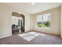 Bright living room with neutral walls, large window with blinds, and carpeted floors at 1417 Sterlingbrooke Dr, Powder Springs, GA 30127