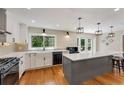 Open kitchen featuring a large island, white cabinets, modern appliances, and hardwood floors at 2356 Defoors Ferry Nw Rd, Atlanta, GA 30318