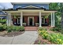 Inviting brick porch with elegant columns, offering a relaxing outdoor space with stylish seating and planters at 3715 Horizon Ct, Cumming, GA 30041