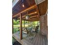 Comfortable covered back porch with seating area, string lights and wood beam roof at 4715 Howard Dr, Powder Springs, GA 30127