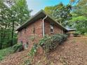 A full brick home with green trim and mature landscaping sits on a wooded lot at 1512 Pine Cir, Lawrenceville, GA 30044
