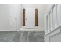 Inviting entryway features white wainscoting, tiled floor, gray carpeted stairs, and front door at 2837 Lakewater Way, Snellville, GA 30039
