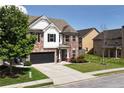 Charming two-story home with a brick and white facade, black garage door, and well-maintained lawn at 4171 Towncastle Ln, Buford, GA 30518