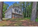 View of a two story home featuring a brick facade and light gray siding surrounded by trees at 752 Roxboro Trce, Lawrenceville, GA 30044